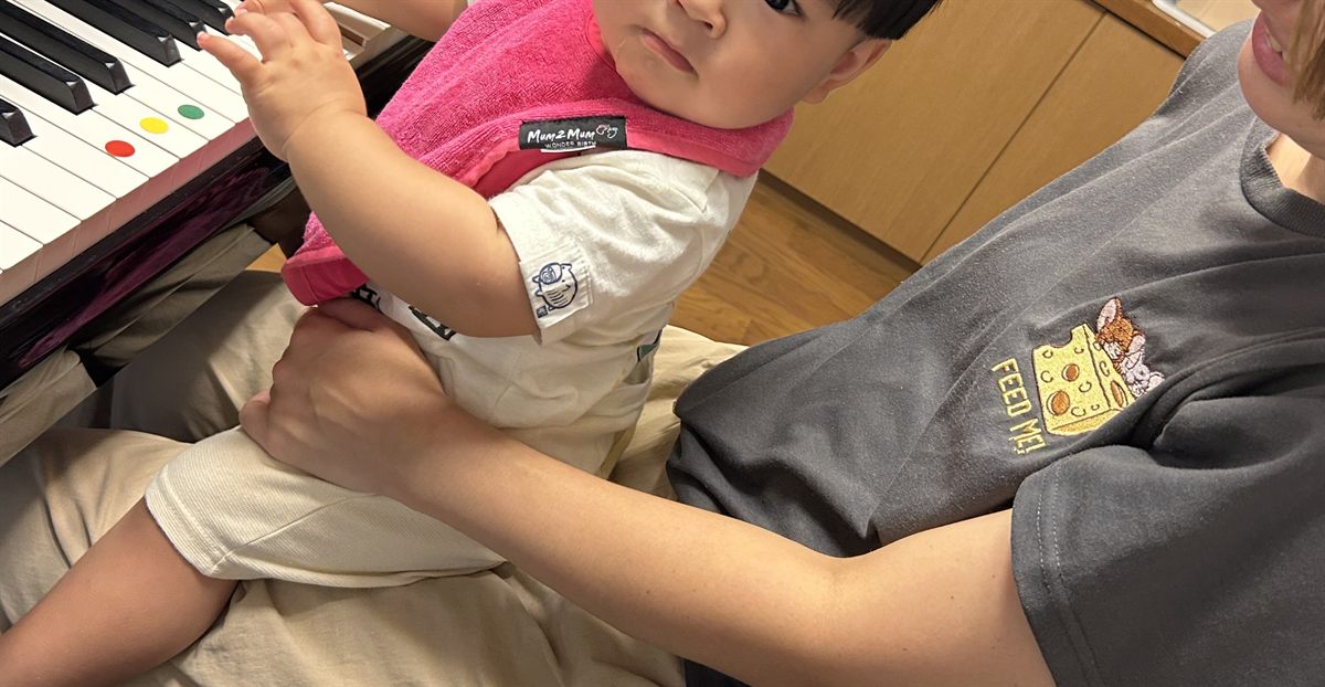 鍵盤に手をのばす1歳の子ども